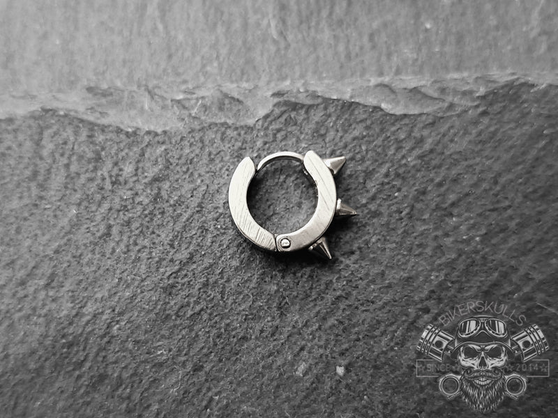 Questo orecchino si distingue per il suo look audace e aggressivo caratterizzato da una forma ad anello con tre punte frontali ed è realizzato in acciaio inossidabile lucido.