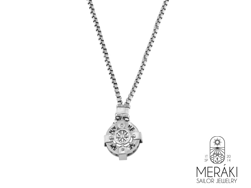 Collana in acciaio inossidabile lucidato, dal design insolito. Il pendente a cappio è a forma di timone argentato, al di sotto del quale figurano i punti cardinali che rendono ancor più maschile questa collana.