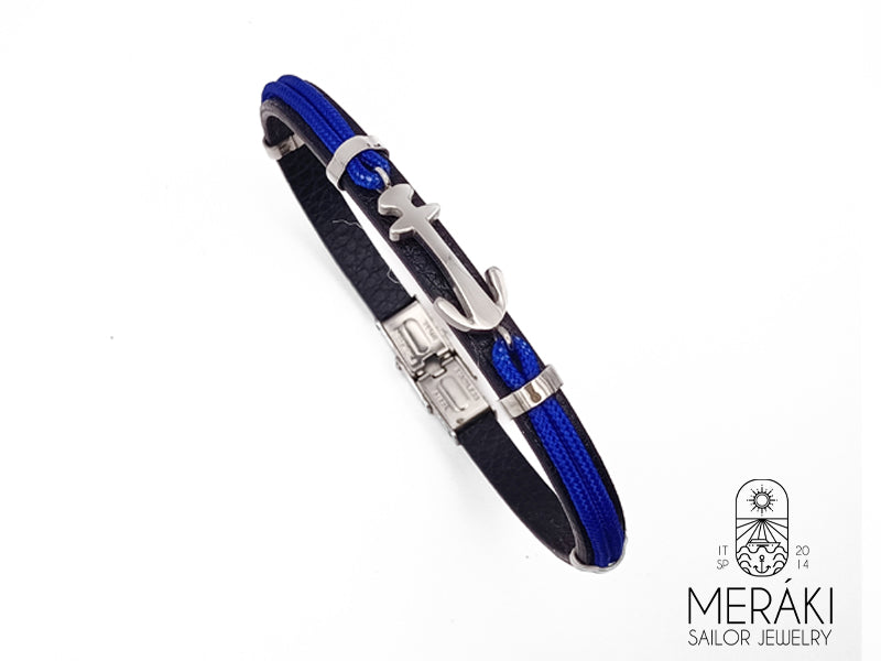 Questo bracciale in pelle e cordino nautico ha una decorazione con un'ancora nella parte anteriore e la base in vera pelle