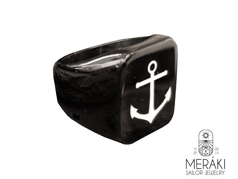 Anello realizzato in titanio con incisa un'ancora bianca.