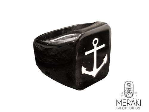 Anello realizzato in titanio con incisa un'ancora bianca.
