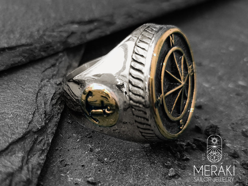 Anello in acciaio lucido argentato con sigilli a forma di rosa dei venti e ancore laterali dorate