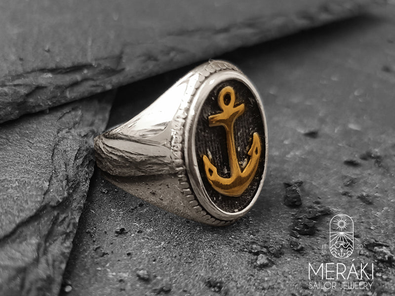 Meraki anello Brishon in acciaio lucido con ancora frontale dorata
