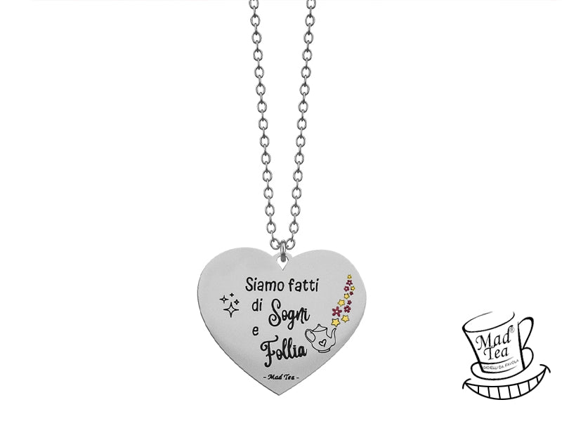 Collana con ciondolo a forma di cuore con incisa la frase “Siamo fatti di Sogni e Follia” e una piccola teiera che versa un tè fatto di fiori e stelle. 