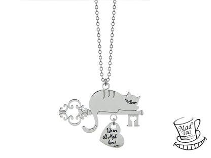Collana con Gatto del Cheshire sdraiato sulla chiave della porta di Wonderland e ciondolo pendente a forma di cuore con incisa la frase “We are all Mad here!” ossia “Siamo tutti matti qui!”.