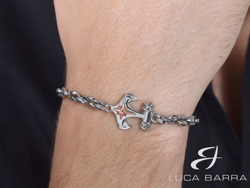 L'ancora, simbolo di stabilità e resilienza, è abbinata alla rosa dei venti, indicando la direzione e l'orientamento nella vita. Il rivestimento IP Rose aggiunge un tocco di eleganza e calore al design, creando un contrasto audace e raffinato.