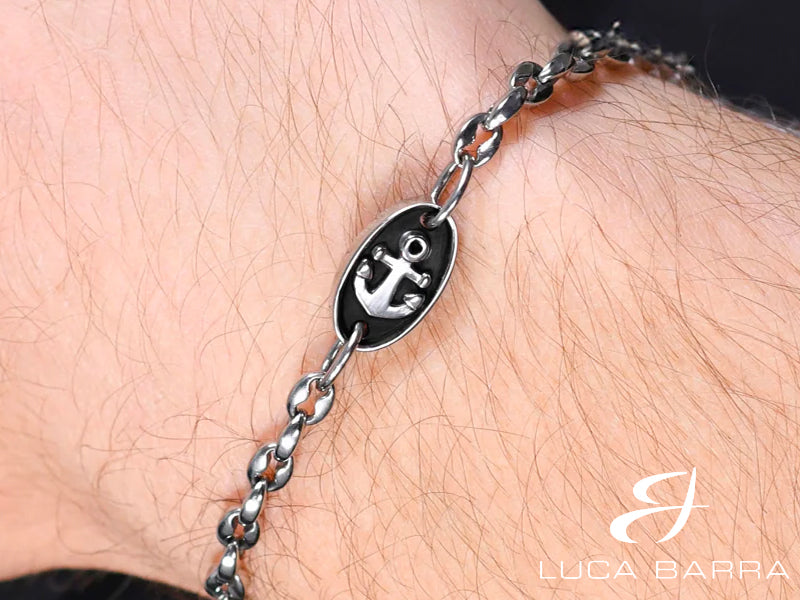 Bracciale Uomo in acciaio con elemento smaltato con ancora. L'ancora è simbolo di stabilità e sicurezza, poiché rappresenta la capacità di rimanere saldi anche nelle tempeste della vita. Il bracciale simboleggia la forza interiore e la capacità di affrontare le difficoltà con risolutezza.