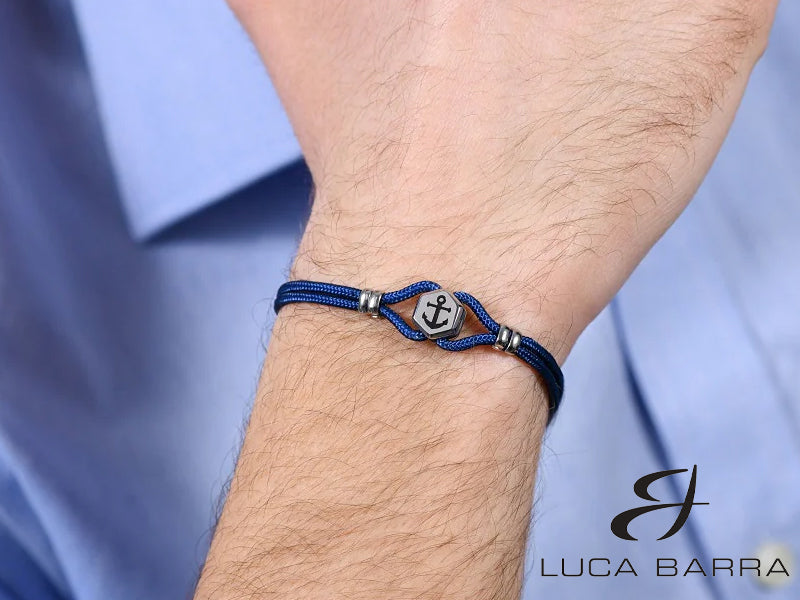 Bracciale Uomo in corda blu con elemento in acciaio con ancora smaltata nera. L'ancora è simbolo di stabilità e sicurezza, poiché rappresenta la capacità di rimanere saldi anche nelle tempeste della vita. Il bracciale simboleggia la forza interiore e la capacità di affrontare le difficoltà con risolutezza. Il colore blu è spesso associato alla serenità e alla calma, soprattutto quando si tratta di temi legati al mare e al cielo.