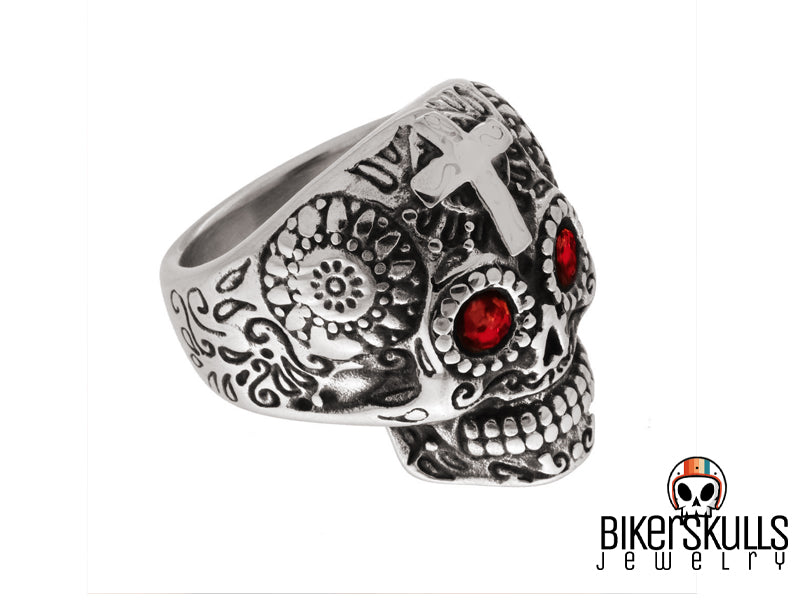 Anello dal design accuratamente realizzato raffigurante un Mexican Skull con croce sulla fronte, occhi con cristalli rossi e ampi intagli floreali tribali su tutto il cranio. Il giusto anello per attirare l'attenzione desiderata.Anello Sugar Mexican Skull in acciaio 316L by Biker Skulls