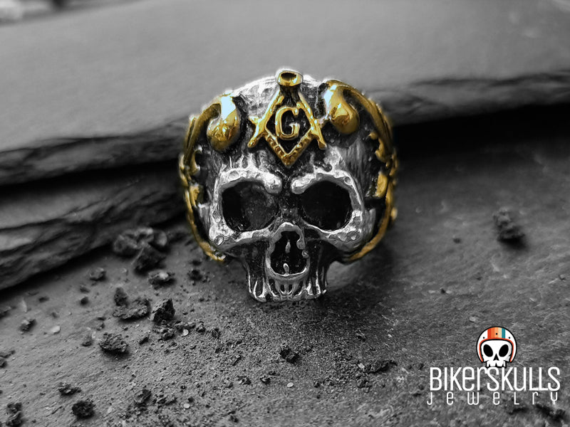 Anello caratterizzato da un teschio molto dettagliato dagli occhi neri e profondi con simboli massonici a contrasto in dorato, non passerà sicuramente inosservato ed attirerà sicuramente l'attenzione.