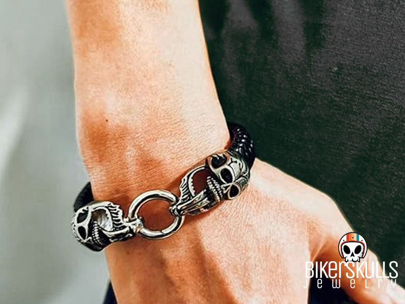 questo braccialetto in pelle intrecciata è decorato con due teschi che collegano la chiusura da ciascuna estremità del braccialetto. L'aspetto audace e potente dice molto sulla personalità della persona che lo indossa. Progettato per essere comodo e facile da indossare, questo bracciale offre un'aggiunta alla moda al tuo outfit quotidiano e molte possibilità per evidenziare il tuo stile