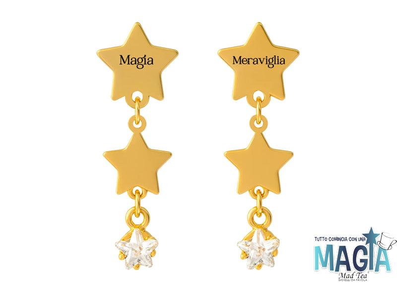 Orecchini in acciaio dorato composti da stelle pendenti e cristallo con inciso nella prima montatura “Magia” e nell’altra “Meraviglia”.