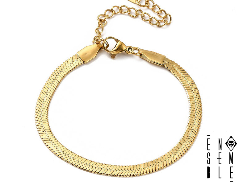 Questo braccialetto è realizzato in acciaio inossidabile di alta qualità con finitura dorata, con una maglia snake flat che ricorda la sinuosità di un serpente. La sua superficie liscia e la chiusura a moschettone garantiscono comfort e sicurezza. Un accessorio versatile, ideale per ogni occasione.
