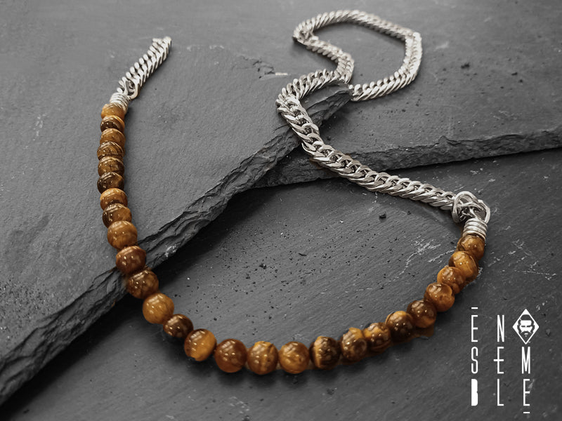 Collana realizzata con catena a maglie in acciaio inossidabile robuste e resistenti e perle Occhio di Tigre. Si chiude saldamente al collo con una chiusura a moschettone.