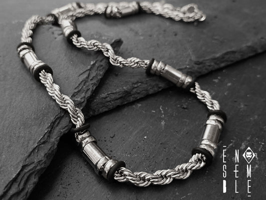 Collana realizzata con catena a maglie Twist intrecciate in acciaio inossidabile alternato ad elementi di acciaio tono su tono .