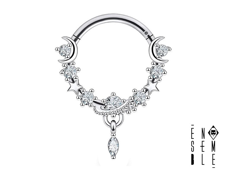 Il piercing septum è realizzato in acciaio chirurgico 316L, con un diametro interno di 10 mm. Presenta sette zirconi di varie misure incastonati sull'anello, e un ciondolo con due lune e due stelline, anch'essi tempestati di zirconi.