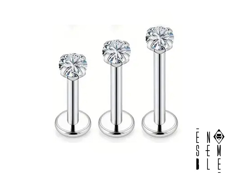 Il piercing labret è realizzato in acciaio inossidabile 304L di alta qualità, con finitura lucida. La barretta, disponibile in 3 lunghezze (6, 8 e 10 mm), è sormontata da un brillante zircone cubico da 3 mm di diametro, che cattura e riflette la luce, creando un effetto scintillante.