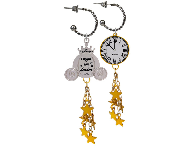 Questi orecchini ad anella componibili rappresentano tutta l’essenza della favola di Cenerentola. Da una parte abbiamo infatti l’orologio che segna l’avvicinarsi della mezzanotte e dall’altra la famosa carrozza a forma di zucca con incisa la frase “I sogni son desideri”.  Al centro dell’ orologio è incastonato un piccolo cristallo come punto luce e nel retro è incisa la frase “Il sogno diventa realtà”. Entrambi sono arricchiti da una pioggia di magia composta da tante stelline dorate.