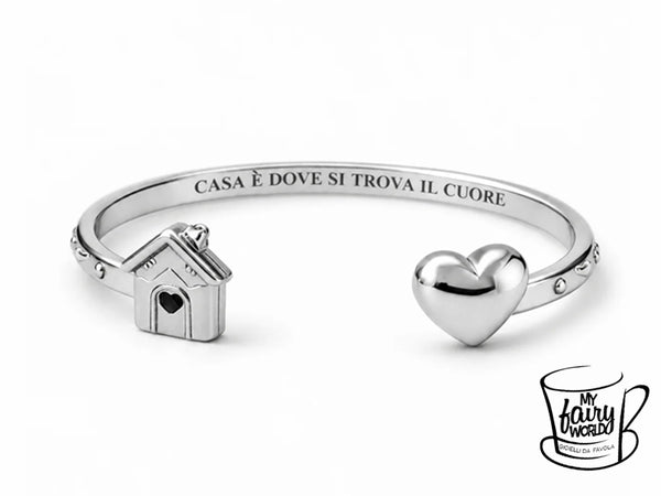 Bracciale regolabile in acciaio inossidabile, luminoso e pensato per avvolgere delicatamente il polso. Il modello è decorato con casetta e cuore tridimensionali e custodisce all’interno la scritta “CASA È DOVE SI TROVA IL CUORE!”