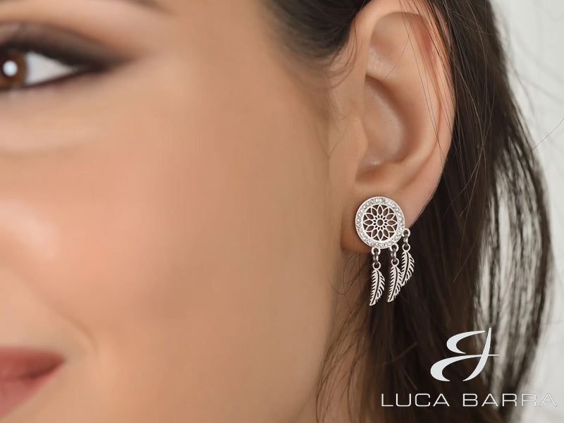 Gli orecchini donna in acciaio con acchiappasogni e cristalli bianchi sono un gioiello unico e affascinante che cattura l'immaginazione e aggiunge un tocco di spiritualità al tuo stile. Questi orecchini presentano un design ispirato agli acchiappasogni, simbolo di protezione e buoni auspici.