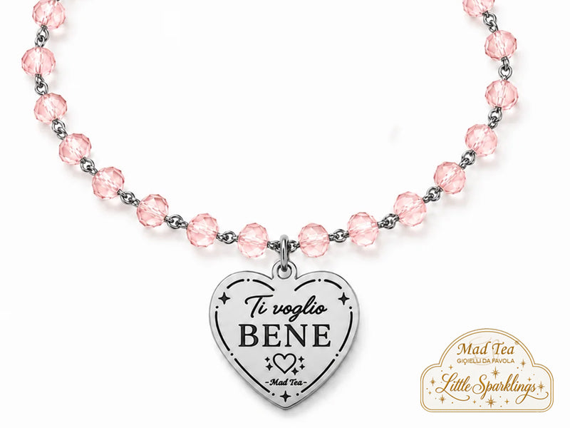 I cristalli rosa gli regalano una luce delicata e femminile, mentre il ciondolo a cuore con la scritta “Ti voglio bene” racchiude un messaggio piccolo solo nelle parole, ma enorme nel significato.