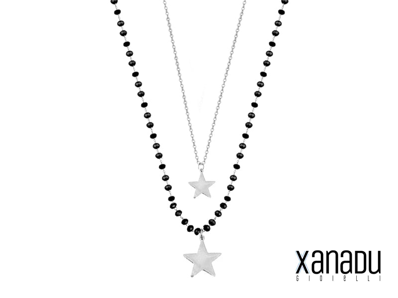 Eleganza e mistero si fondono in questa collana a due file. Una delicata catenella in acciaio con stella si intreccia con una più lunga catena di cristalli neri, impreziosita da una stella più grande. Un gioiello perfetto per ogni occasione, realizzata interamente in acciaio inossidabile