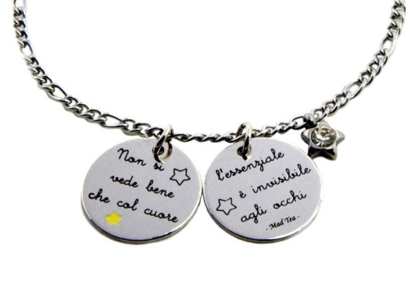 Il bracciale “L’essenziale è invisibile agli occhi” si ispira alla celebre frase del racconto di Antoine de Saint-Exupéry “Il Piccolo Principe”. È in acciaio anallergico, formato da una catena ad anellini e due ciondoli tondi e piatti con incisa la scritta “Non si vede bene che col cuore, l’essenziale è invisibile agli occhi”; accanto troviamo anche un piccolo ciondolino a forma di stellina con al centro un cristallo. .