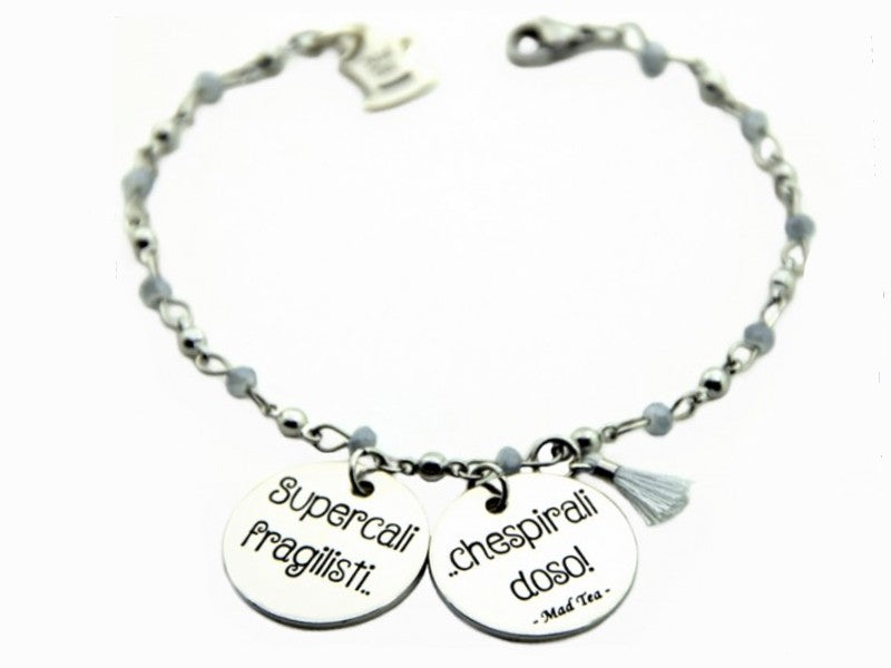 Il bracciale Supercalifragili è dedicato alla stravagante tata rinomata in tutto il mondo, Mary Poppins, che con la sua borsa e il suo ombrello sa catapultarti nel suo magico mondo. È in acciaio anallergico, formato da una catena a pallini alternati a delle pietrine grigie, due ciondoli tondi piatti e una piccola nappina dello stesso colore delle pietrine; sulle due piastrine troviamo incisa la frase “Supercalifragilistichespiralidoso”.