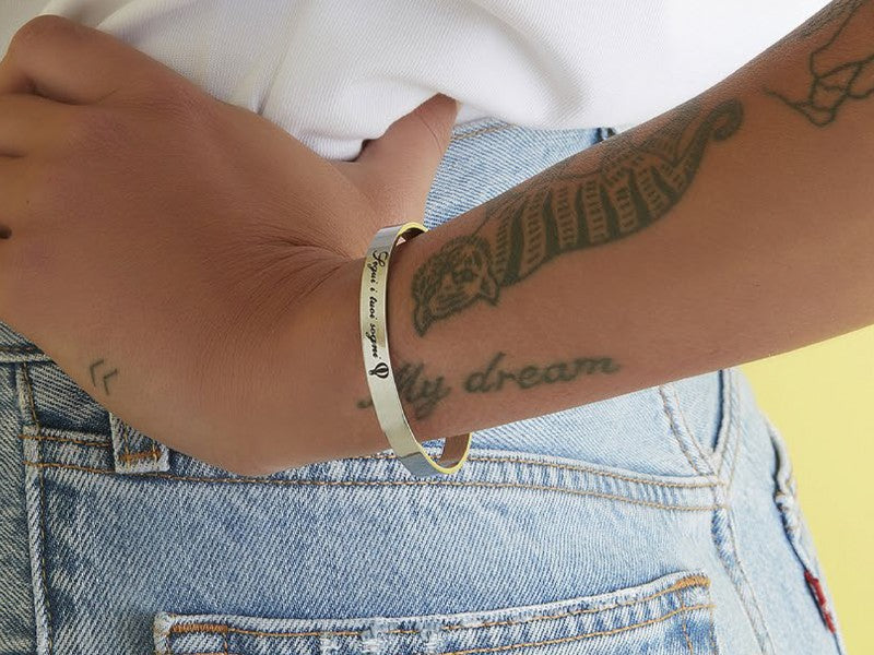 ragazza tatuata con bracciale bangle in acciaio e scritta segui i tuoi sogni con mongolfiera ispirato alla favola di UP