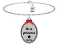 "La vera principessa resta dolce. Resta coraggiosa. Testa alta e cuore in mano."  Questo bracciale rappresenta la forza di noi donne, dolci e determinate allo stesso tempo!  Bracciale con ciondolo ovale sovrastato dal fiocco rosso di Biancaneve con all'interno incisa la frase "Be a princess" e l'iconica mela avvelenata.