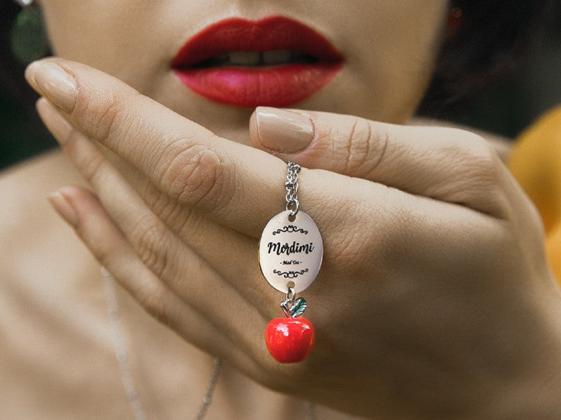 Collana in acciaio con mela avvelenata di biancaneve e ciondolo inciso con scritta Mordimi, d'altronde posso resistere a tutto ma non alle tentazioni 