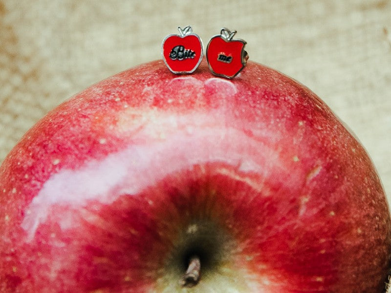 Orecchini con mela morsa di Biancaneve e la frase incisa "Bite me" ossia "Mordimi".