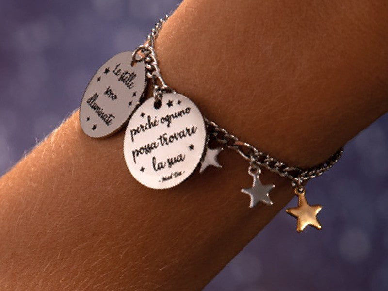 Il Piccolo Principe aveva proprio ragione:; tutti abbiamo una stella che brilla lassù! Bracciale con ciondolo con incisa la frase "Le stelle sono illuminate perché ognuno un giorno possa trovare la sua" e serie di piccole stelline pendenti lungo la catena. La stellina dorata rappresenta la nostra stella che brilla su tutte le altre.