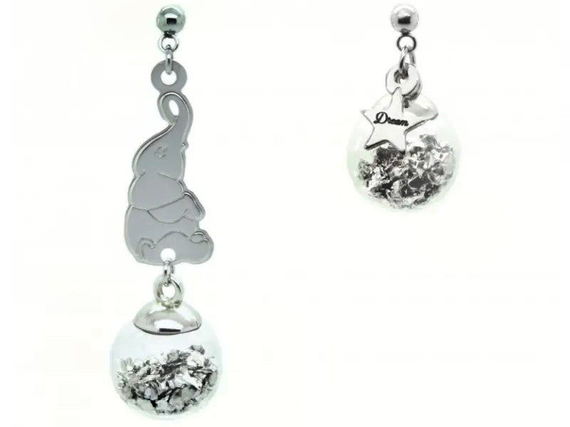 Orecchini asimmetrici con il piccolo Dumbo in equilibrio sulla palla e piccola stellina pendente con incisa la parola "dream" a richiamo del suo grande sogno di diventare una vera star del circo.