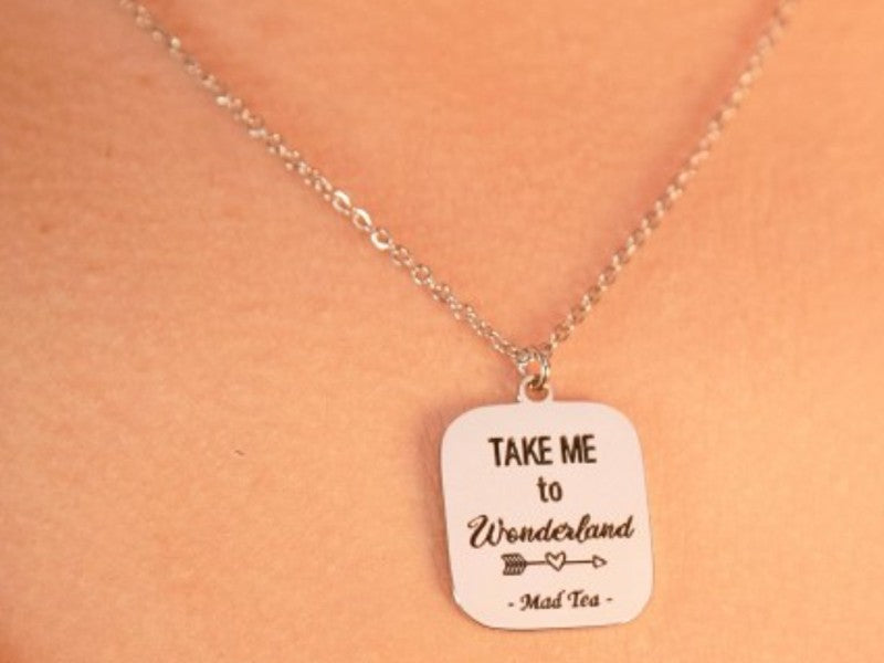 Collana con ciondolo a forma di cartello con incisa la frase "Take me to Wonderland".