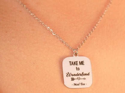Collana con ciondolo a forma di cartello con incisa la frase "Take me to Wonderland".