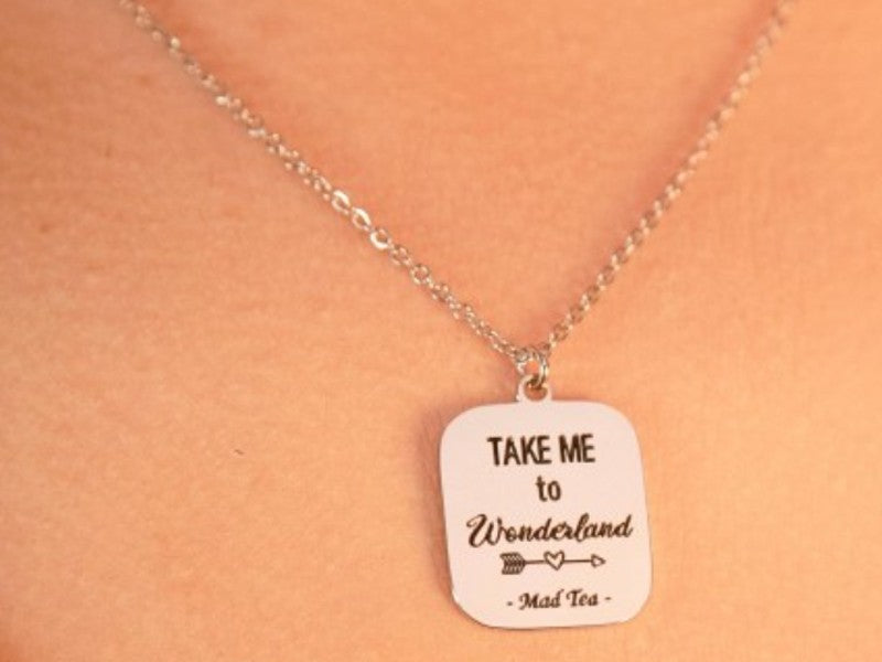 Collana con ciondolo a forma di cartello con incisa la frase "Take me to Wonderland".