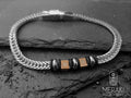 Bracciale realizzato con maglia snake piatta e charm centrali con incisi due timoni dorati