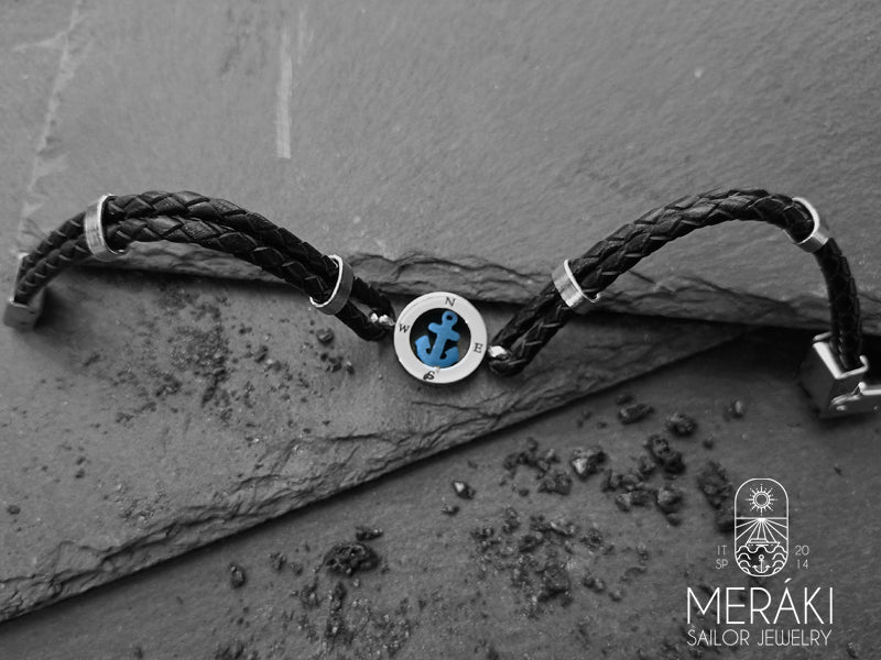 Usando una resistente pelle tressè, il cinturino di questo braccialetto alla moda è molto elegante e abbinato al charm centrale con punti cardinali e ancora blu è perfetto per uscire alla sera o il fine settiman