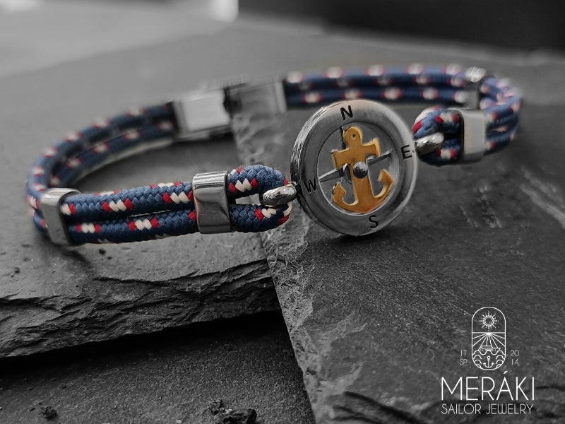 Bracciale cordino nautico bicolor blue e charm centrale rosa dei venti con ancora in contrasto dorata