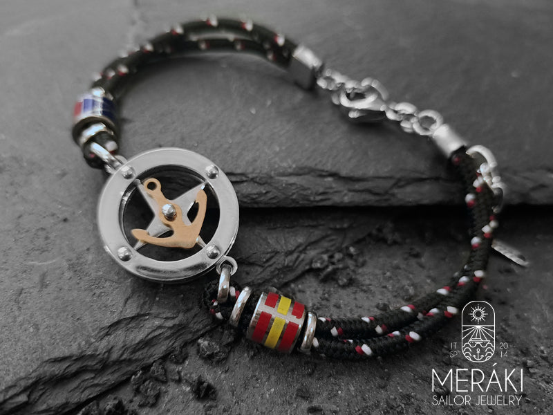 Un braccialetto colorato è la giusta soluzione per vivacizzare anche gli outfit maschili più formali e da ufficio, Noah è realizzato con cordino nautico bicolor rosso e charm centrale con rosa dei venti e ancora dorata girevole a contrasto