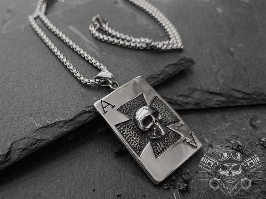 Collana con ciondolo imponente rappresentante una croce dei cavalieri templari con teschio su una carta da gioco.