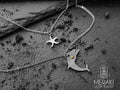 Abbiamo unito la saggezza del delfino alla protezione della stella marina per creare questa doppia collana a maglia fine in tema marinaro.
