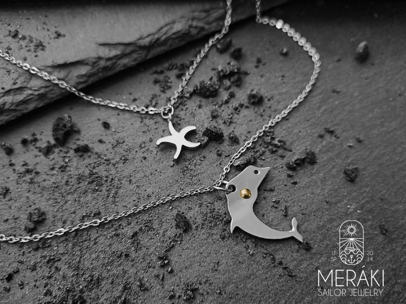 Abbiamo unito la saggezza del delfino alla protezione della stella marina per creare questa doppia collana a maglia fine in tema marinaro.