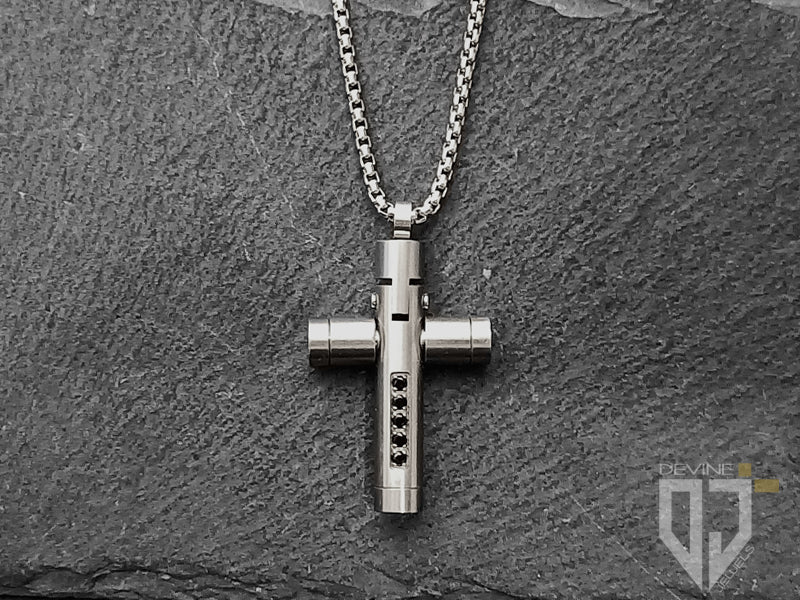 La catena in acciaio inossidabile si fonde perfettamente con la croce lucida impreziosita da cinque granati neri di zirconi cubici e si fissa con una chiusura a moschettone facile da usare. 