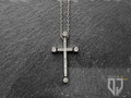 La catena in acciaio inossidabile si fonde perfettamente con la croce lucida impreziosita da ventiquattro piccoli granati bianchi di zirconi cubici e da quattro più grandi all'estremità e si fissa con una chiusura a moschettone facile da usare. 