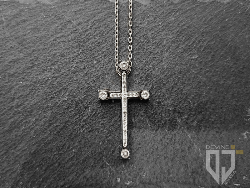 La catena in acciaio inossidabile si fonde perfettamente con la croce lucida impreziosita da ventiquattro piccoli granati bianchi di zirconi cubici e da quattro più grandi all'estremità e si fissa con una chiusura a moschettone facile da usare. 