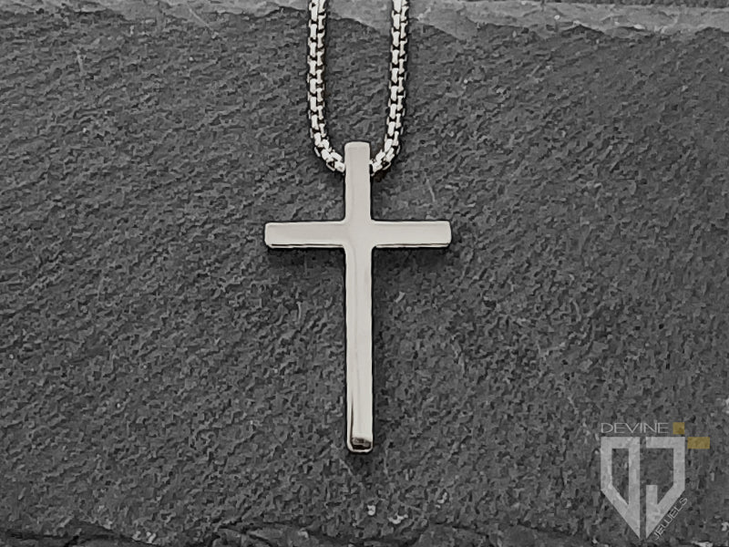 Il ciondolo, un classico della collezione Devine Jewels, è una croce con finitura lucida argentata che si abbina alla perfezione alla catenina maglia box e a qualsiasi outfit 