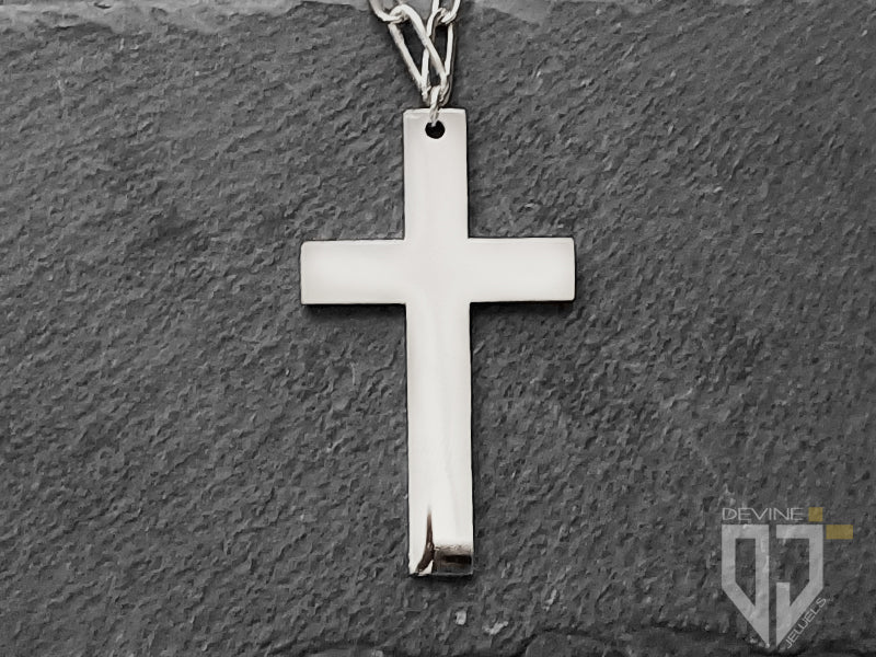 La collana Freyr, qui proposta nella versione argentata, è realizzata in acciaio inossidabile e combina una catenina a maglia larga a due ciondoli, uno a croce e l'altro con madonnina.