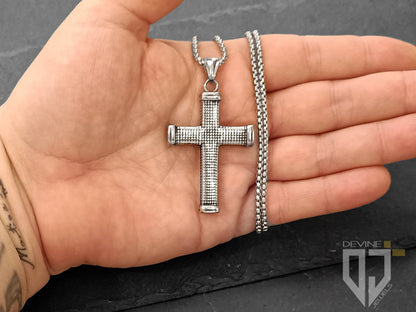 Un pendente a forma di croce borchiata e una catena realizzati in acciaio inossidabile resistente caratterizzati da un'alta lucentezza.